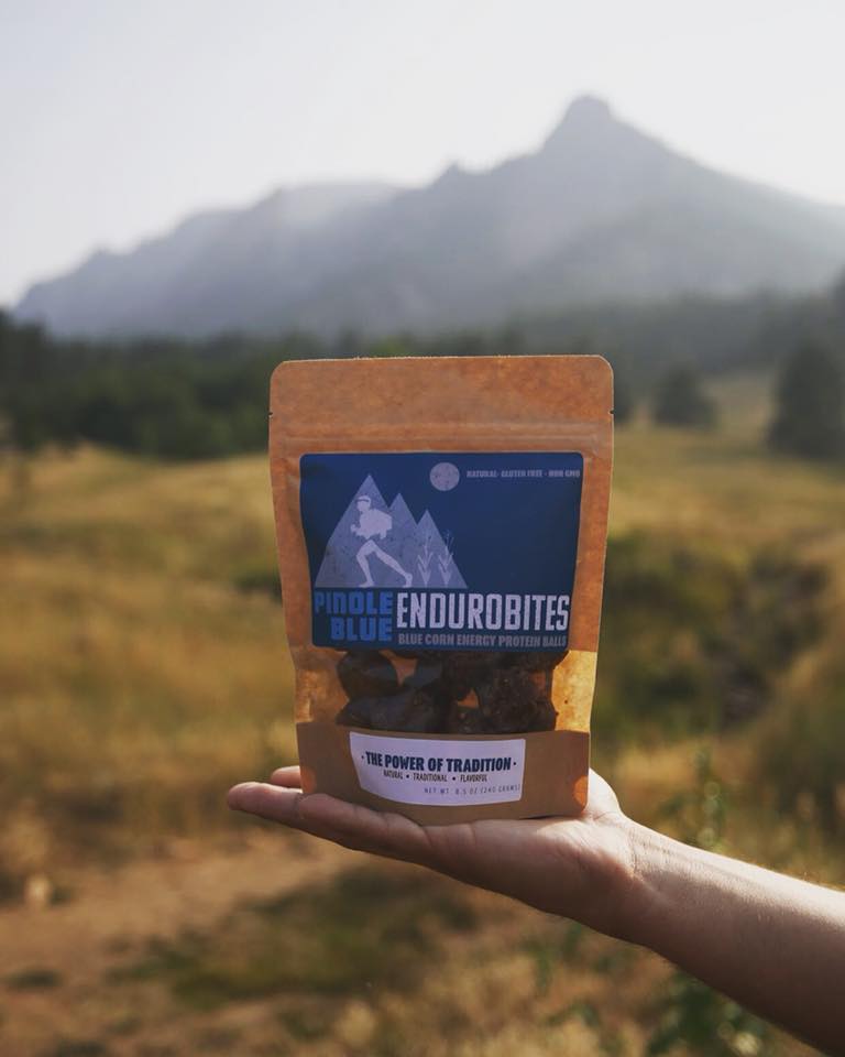Endurobites packaging held out in front of the soft background of a mountain.